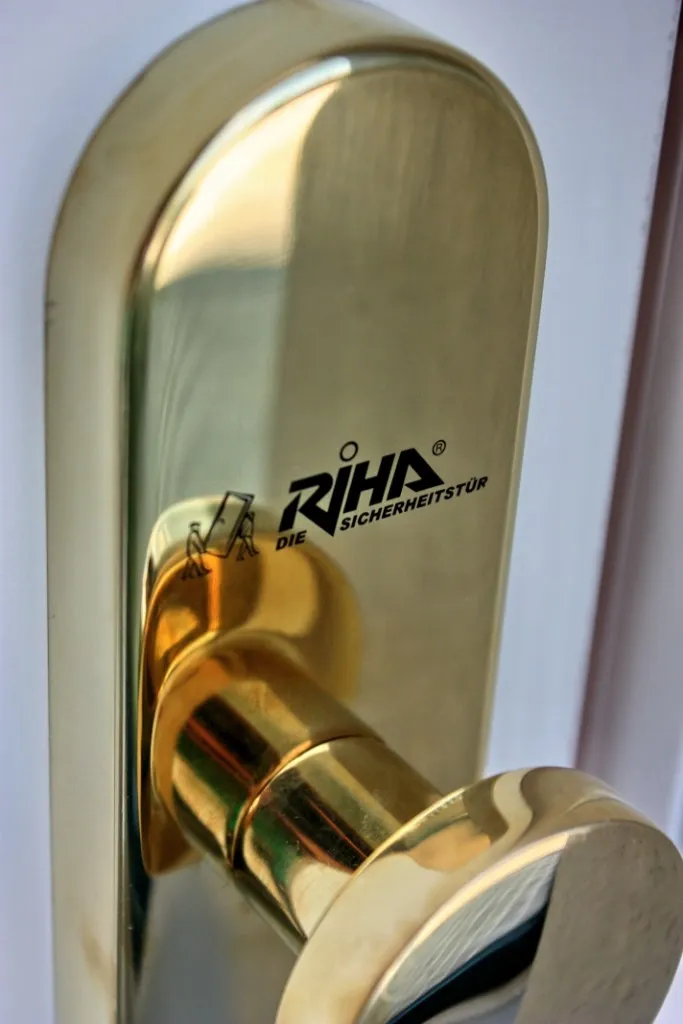 Messing-Türdrücker einer RIHA Sicherheitstür, das Langschild mit dem RIHA-Logo geprägt